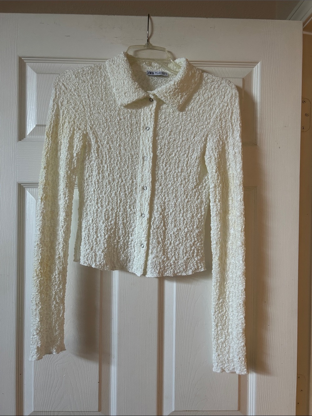 Shaped and cropped textured snap button front long sleeved collared shirt.
